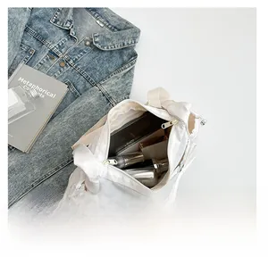 Vue de dessus du sac bandoulière blanc montrant l'intérieur spacieux pour tablette