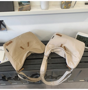 Detail of khaki and beige nylon messenger bags with brown leather accents and wide straps