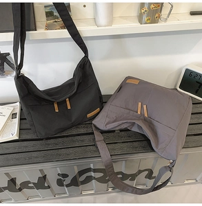 Detail view of black and grey large capacity nylon crossbody bags with adjustable straps