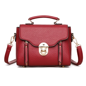 Retro burgundy leather handbag with gold twist lock and crossbody strap on white background