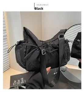 Détail du sac à épaule en nylon noir plissé montrant le cordon latéral et le tissu