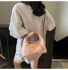 Detail of pink matte texture handbag with adjustable strap and delicate bow decoration