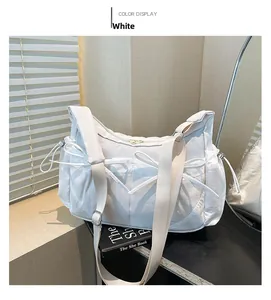 Détail d'un sac bandoulière blanc en nylon avec cordon nœud et large bandoulière chic