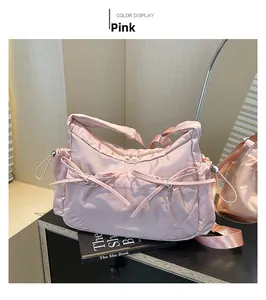 Détail du sac cabas rose en nylon avec nœuds décoratifs et bandoulière réglable