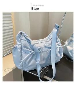 Gros plan d'un sac à bandoulière en nylon bleu avec nœuds décoratifs et boucles métalliques
