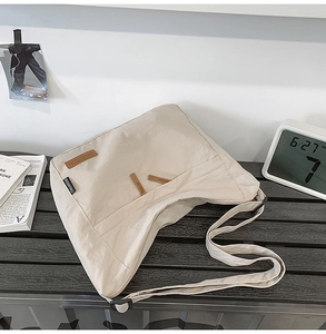Detail view of beige casual shoulder bag with adjustable strap and multiple outer pockets