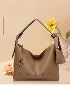 Detail of dark brown pebble leather hobo bag featuring decorative knotted handle accents
