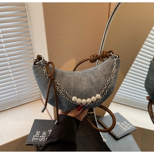 Detail of crescent denim bag with silver chain, white pearls and brown leather strap