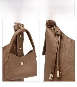 Detail of lychee pattern leather crossbody bag with gold metal buckle and small pouch