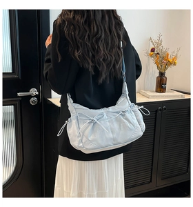 Détail du sac bandoulière en nylon bleu clair avec nœuds de serrage décoratifs