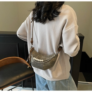 Detail of vintage gray crescent bag with pearl chain and knotted strap on model