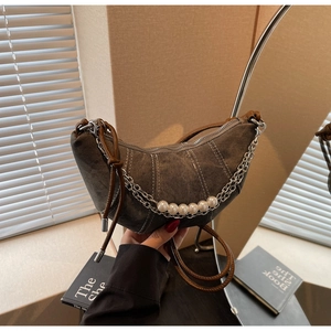 Detail of dark grey crescent bag with contrast stitching and pearl metal chain