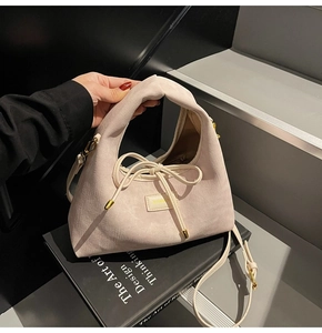 Detail of pink canvas handbag featuring knotted handle and bow drawstring decoration