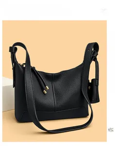 Detail of black lychee grain leather hobo bag with gold hardware and small coin purse