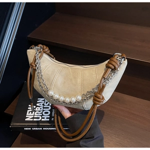 Dettaglio borsa a mezzaluna con catena di perle e tracolla in corda intrecciata