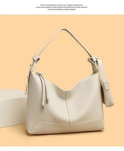 Detail of off-white lychee pattern leather texture and side drawstring on hobo bag