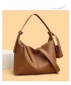 Detail view of brown lychee grain leather hobo bag with adjustable strap and side pouch