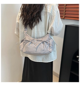 Détail du sac demi-lune en nylon violet clair avec nœuds de serrage porté