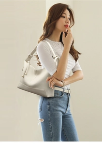 Detail of off-white hobo bag showing pebbled leather texture and adjustable strap