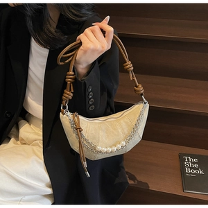 Dettaglio borsa a mezzaluna beige con tracolla intrecciata e catena di perle