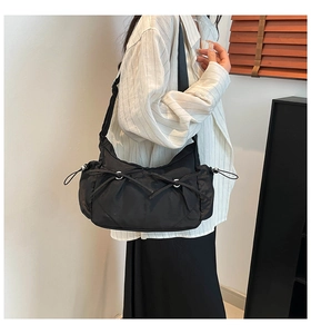 Détail du sac en nylon noir avec cordons à nœuds et large bandoulière pour le quotidien
