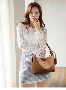 Brown lychee grain leather hobo bag shoulder strap and natural texture detail on model