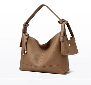 Detail of brown litchi pattern leather hobo bag with shoulder strap knot and mini pouch