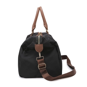 Black travel duffel bag with brown leather handles and adjustable shoulder strap on white base