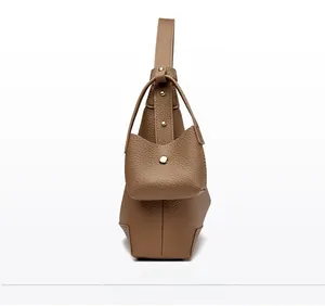 Detail of brown litchi pattern leather bucket bag with gold studs and mini pouch