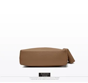Detailed bottom view of brown lychee grain leather crossbody bag with precise stitching