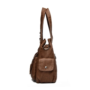 Brown leather shoulder bag with pebbled texture and side pocket shown from side profile