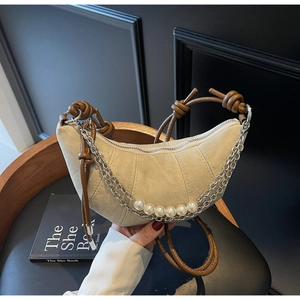 Detailed view of canvas crescent bag with pearl chain and brown knotted shoulder strap