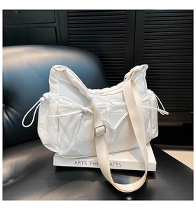 Détail du sac bandoulière en nylon blanc avec nœuds décoratifs et bandoulière réglable