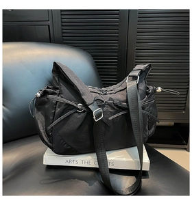 Détail du sac bandoulière noir minimaliste avec nœud coulissant et sangle réglable