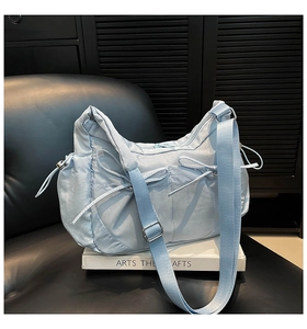 Détail d'un sac bandoulière en nylon bleu clair avec nœuds et cordons de serrage