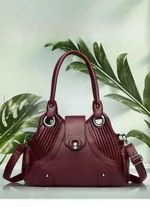 Detail of burgundy pebbled leather handbag featuring silver round lock and rivet accents