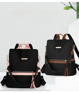 Detail of color-block nylon backpack with tassel zippers and metal brand plaque