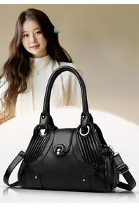 Detail of black lychee grain leather handbag with adjustable strap and vintage metal lock