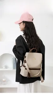 Detail of beige multifunctional backpack with brown straps and anti-theft zipper pocket
