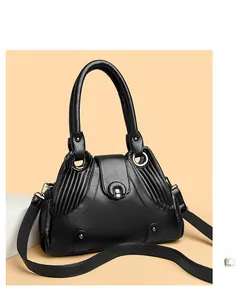 Detail of black pebbled leather texture with horseshoe metal clasp and rivet accents