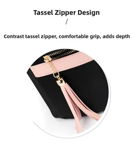 Detail of pink tassel zipper and gold chain hardware on black commuter backpack