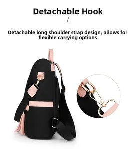 Close-up of detachable gold metal hooks and durable nylon straps on black backpack