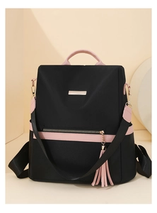 Detail of waterproof nylon backpack with pink leather accents and tassel decoration