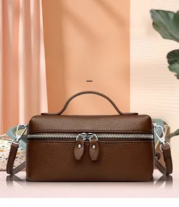 Detailed view of the dark brown lychee pattern leather texture and silver dual zippers