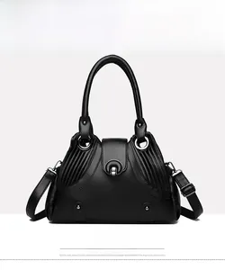 Front detail of black pebble leather handbag with metal buckle and pleated side design