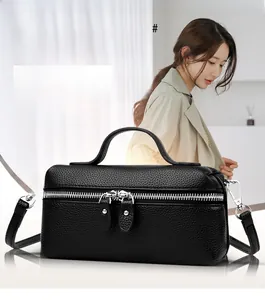 Close-up of black litchi pattern leather box bag with dual silver zippers and handle