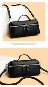 Detail of black lychee grain leather handbag with silver dual zipper and top handle