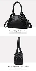 Detailed side view of black lychee grain leather handbag with pleated texture and metal rings
