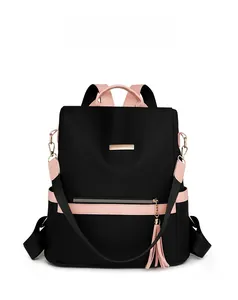 Detail of waterproof nylon backpack featuring pink leather accents and golden metal hardware