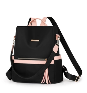 Detail of waterproof nylon backpack with pink leather trim and decorative tassel charm